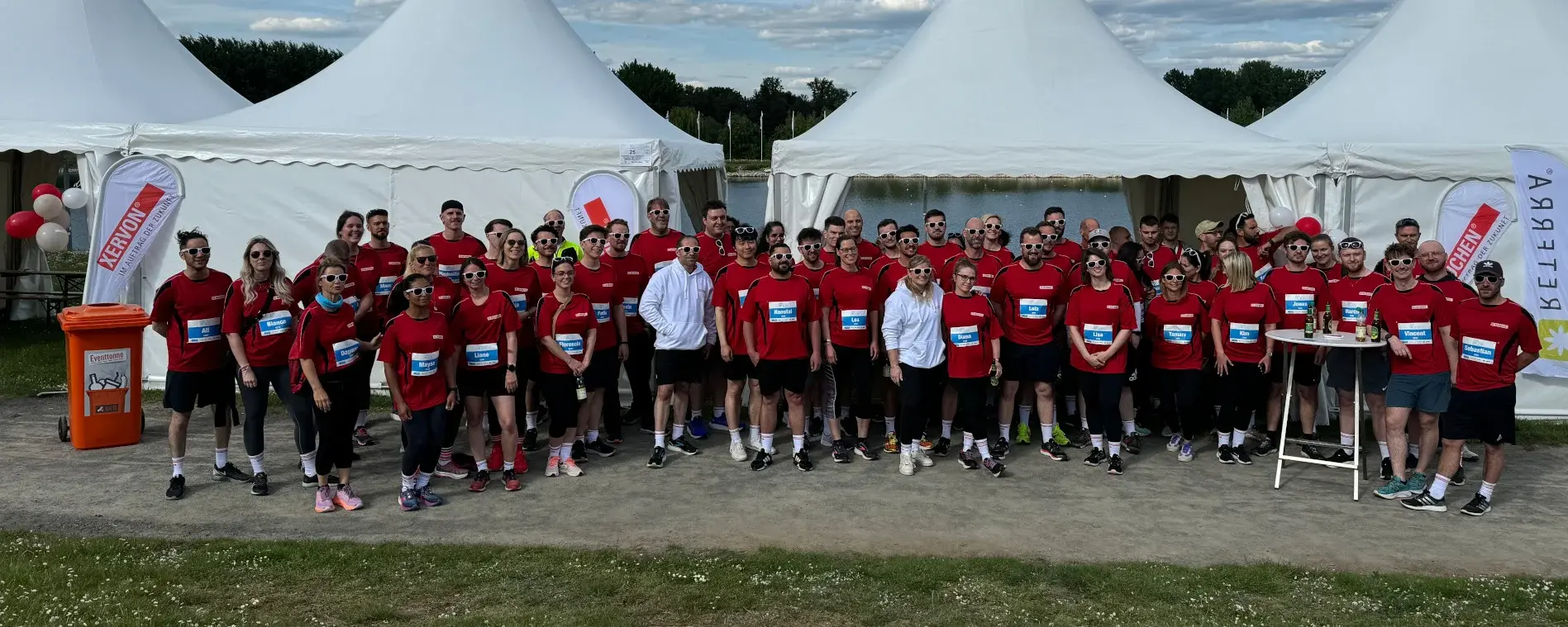 Group photo of employees from RMS companies wearing red company jerseys after the company run.