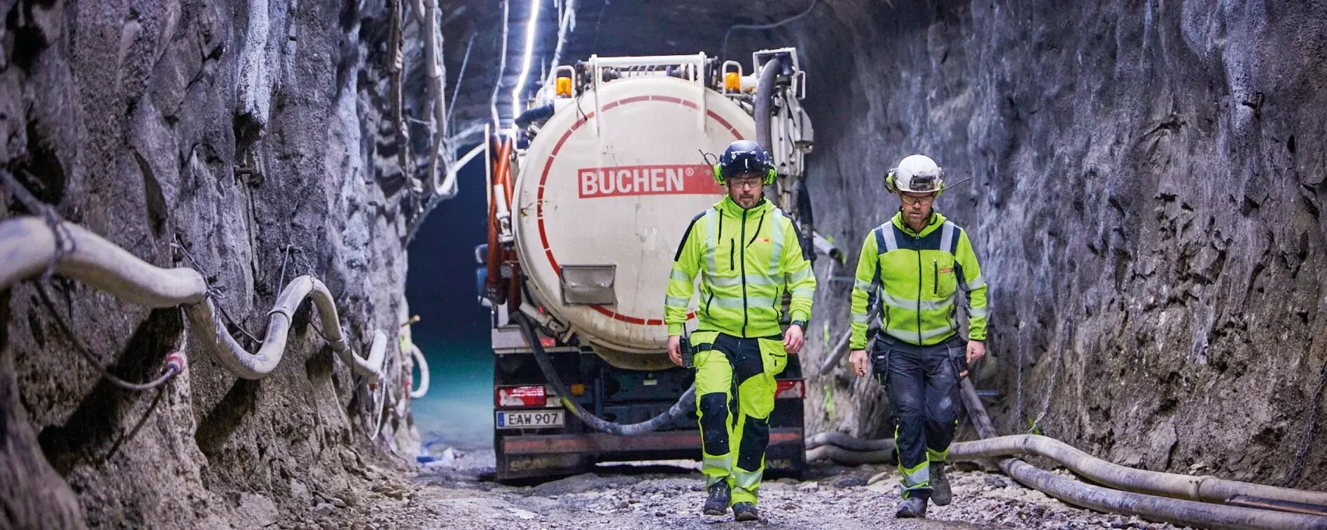 Two men from the BUCHEN Sweden team walk through the Garpenberg mine wearing protective gear.