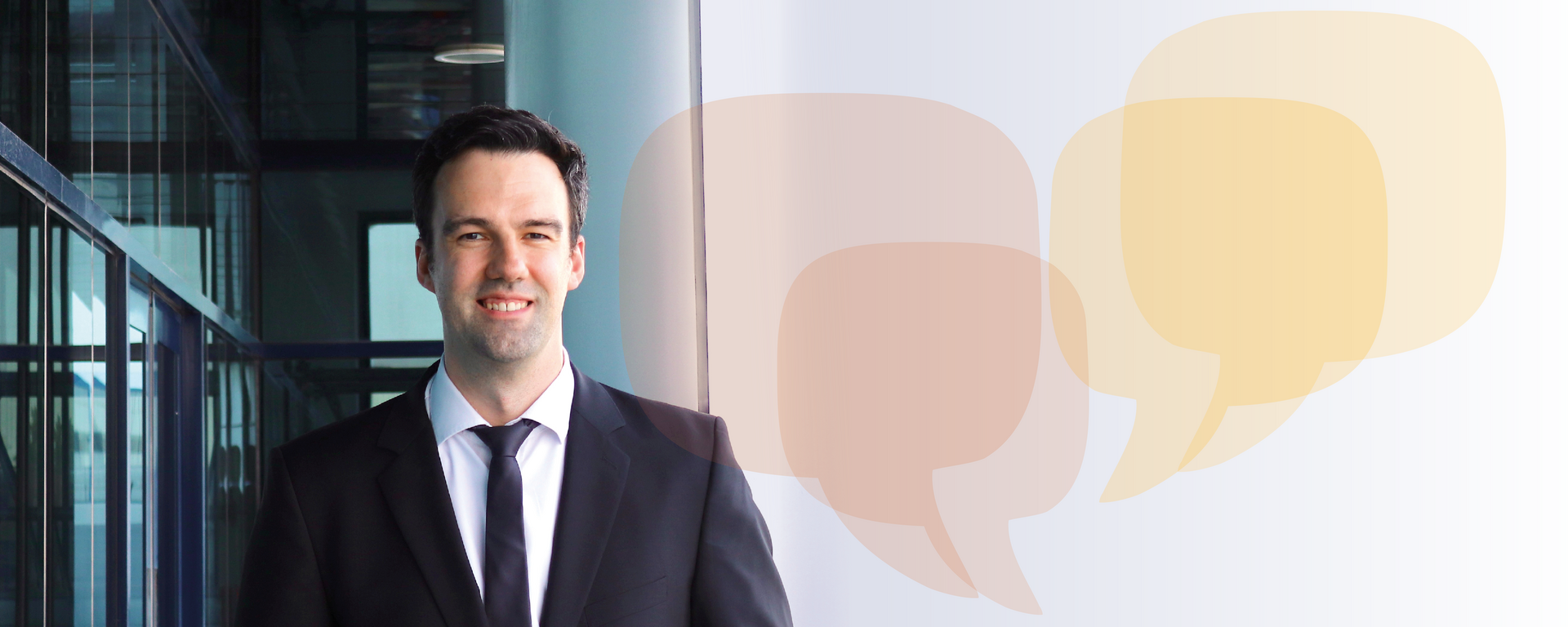 Portrait photo of Timo Blanz in front of a background of pastel-coloured speech bubbles.